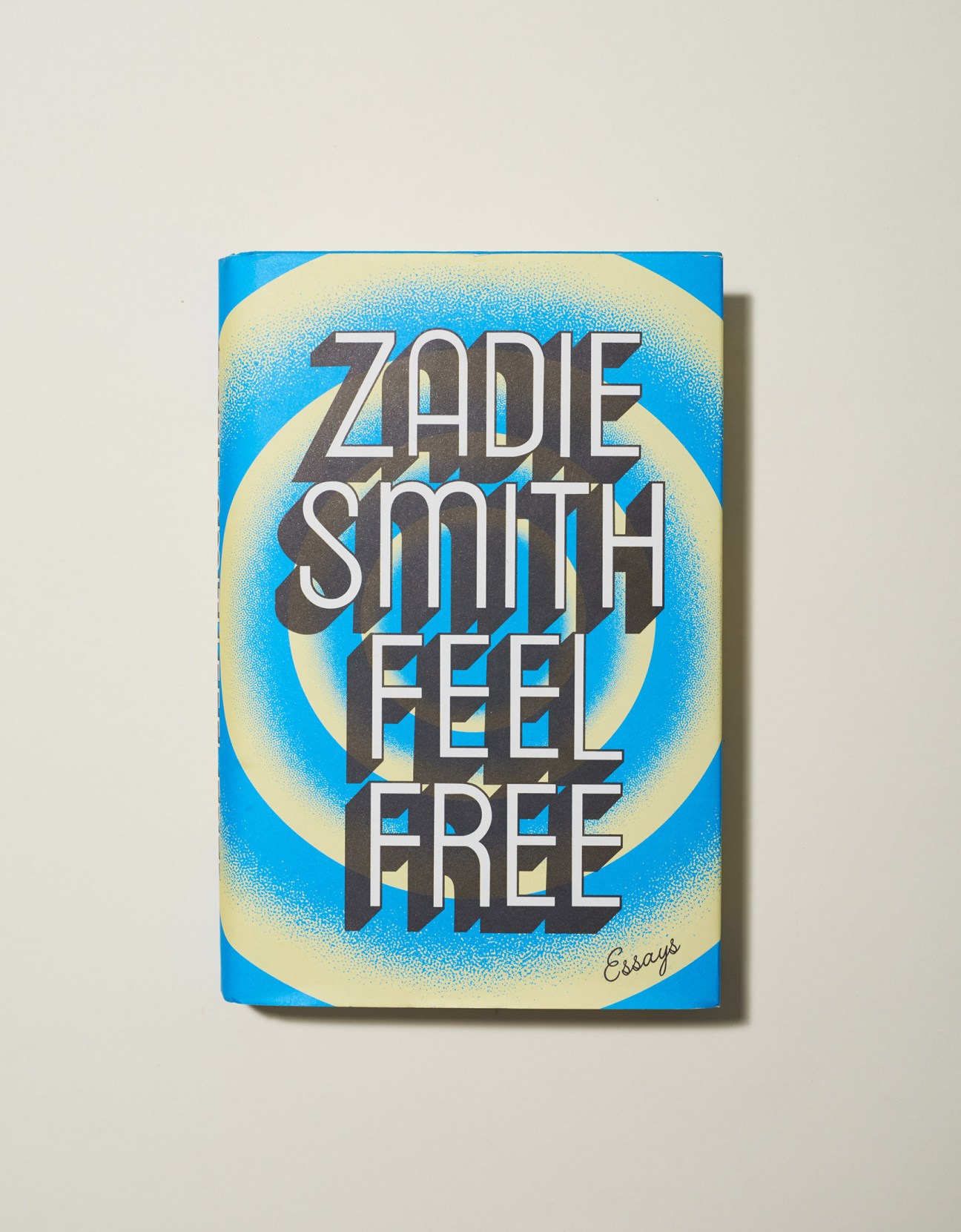 Book cover of 'Feel Free: Essays' by Zadie Smith with blue background and cream oval design