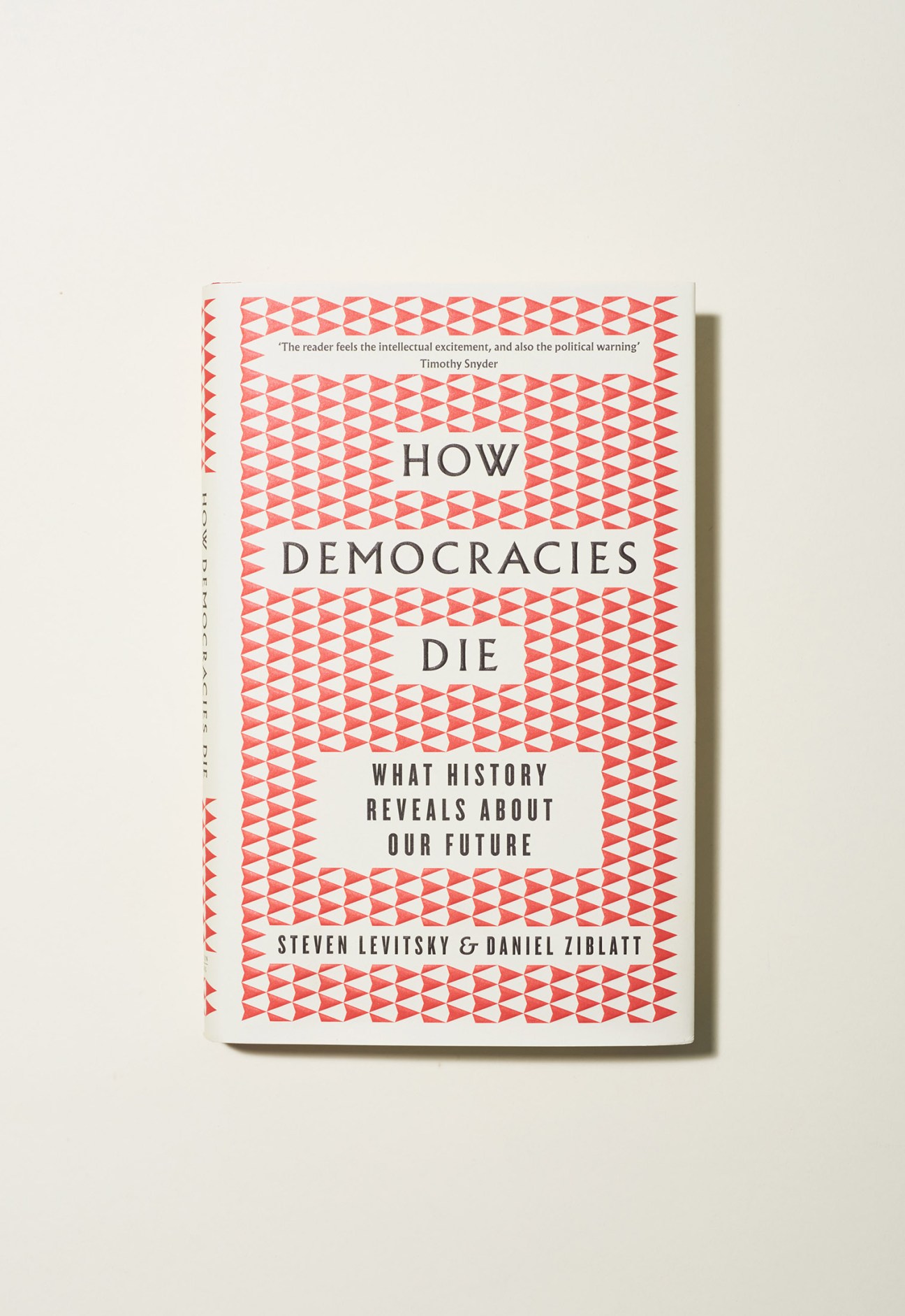 Book cover of 'How Democracies Die' by Steven Levitsky and Daniel Ziblatt with coral geometric pattern.
