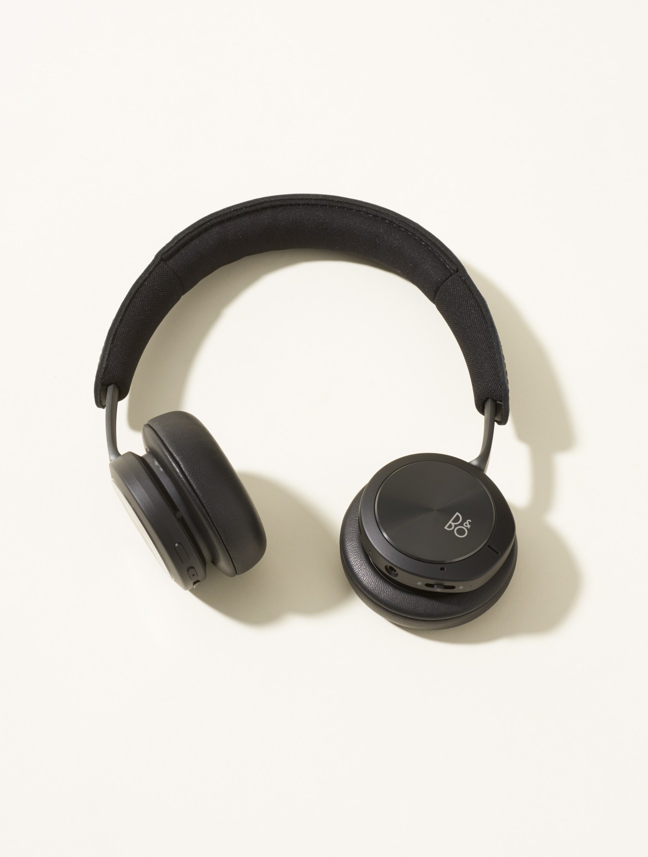 Bang & Olufsen Beoplay h8i headphones with black leather cups and fabric headband on white background.
