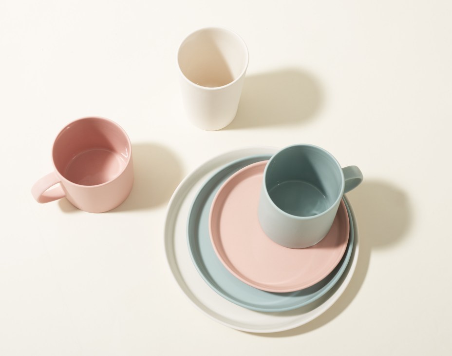 Moheim ceramic tableware in pastel colors including plates, bowls and mugs arranged on white background.