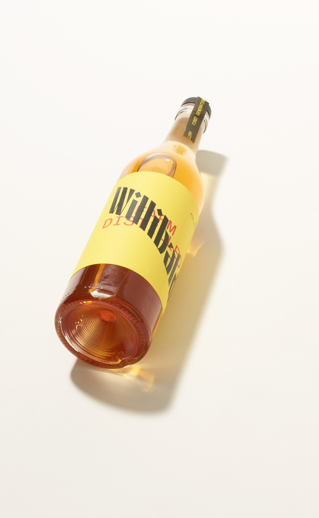 Bottle of Willibald Farm Distillery gin with yellow label and amber-tinted spirit