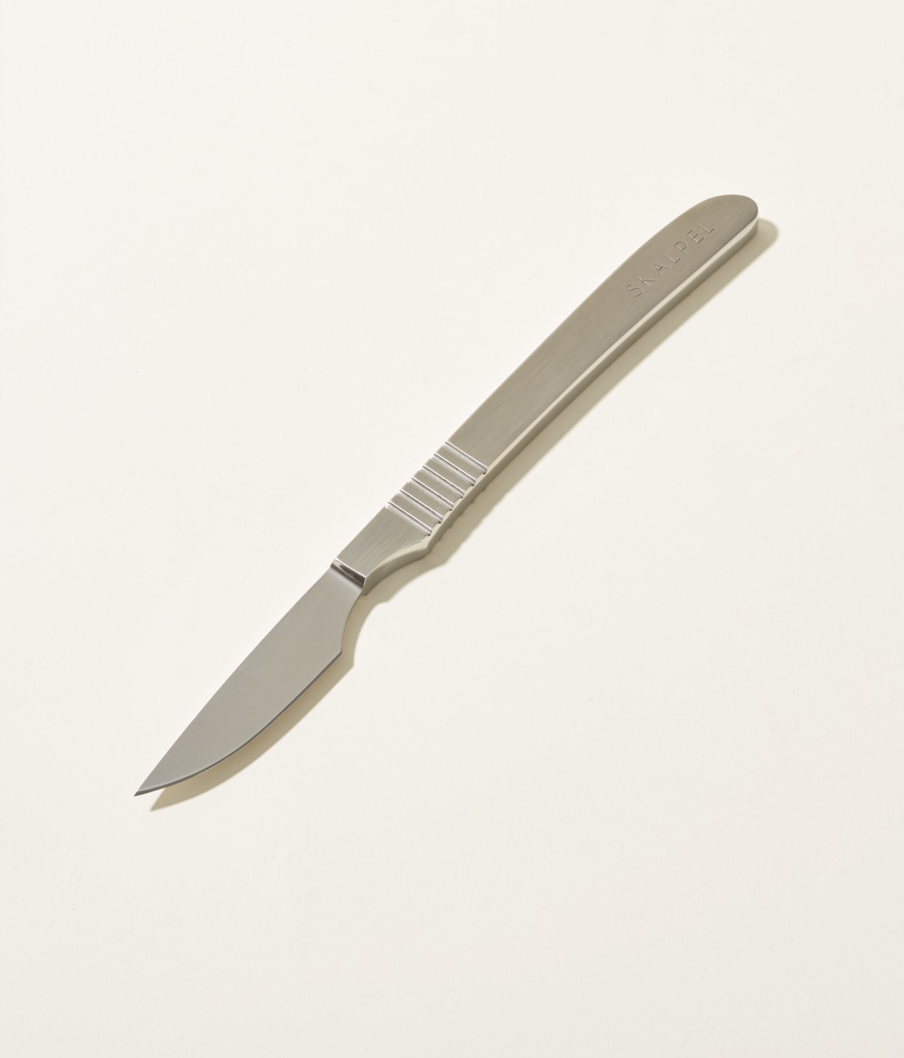 Skalpel steak knife with stainless steel blade and grooved handle on white background.