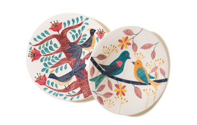 Two decorative ceramic plates with colorful Iranian folk art designs featuring birds and flowering trees.