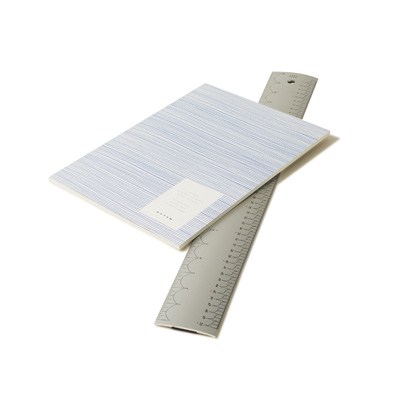 Aluminium ruler and blue notebook on white background