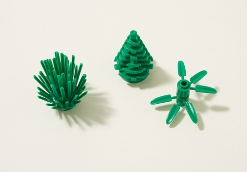 Three green plastic plant figures made from sustainable sugarcane-based material by Lego.