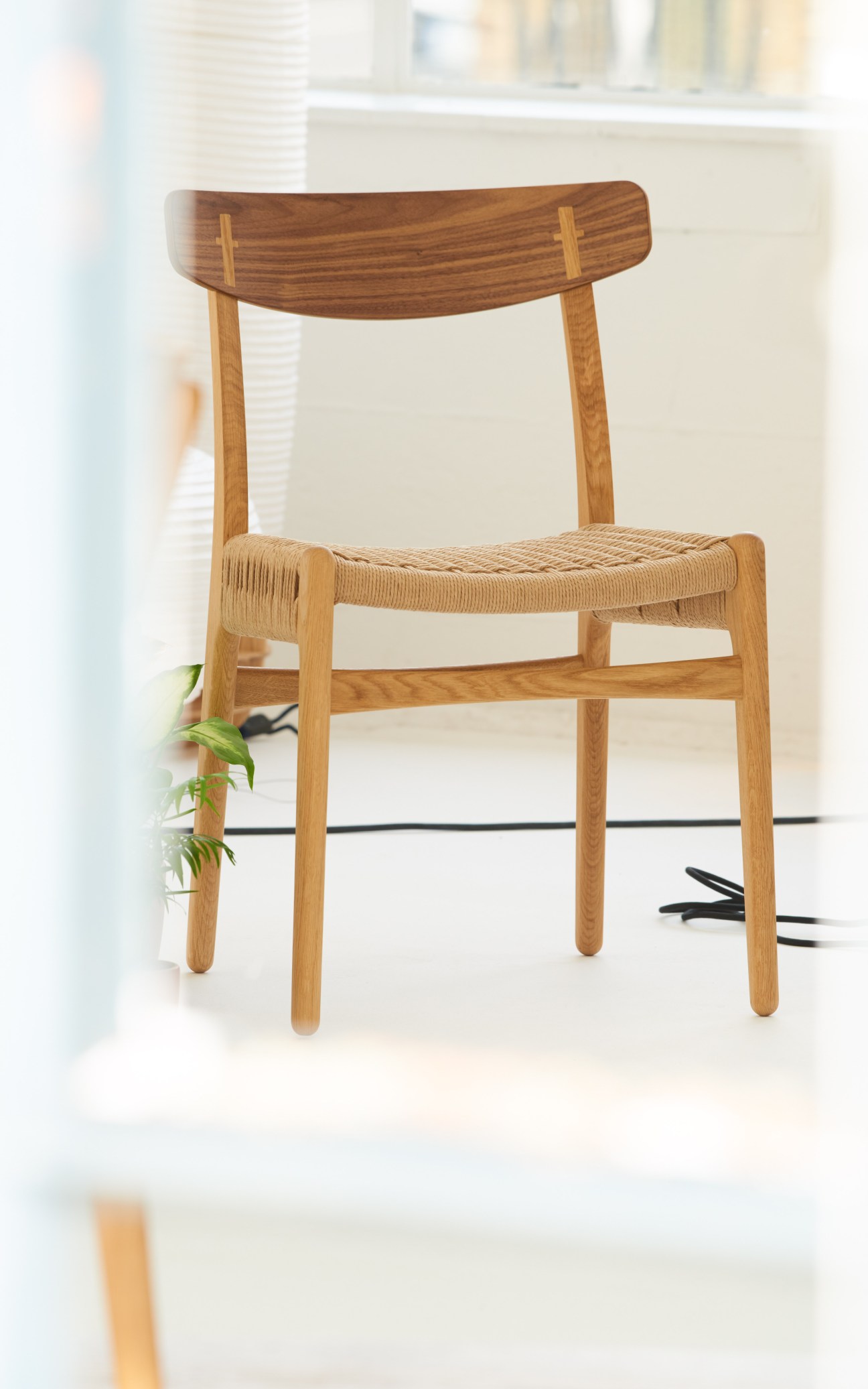 Hans J Wegner CH23 dining chair in oak with woven seat and wooden back.
