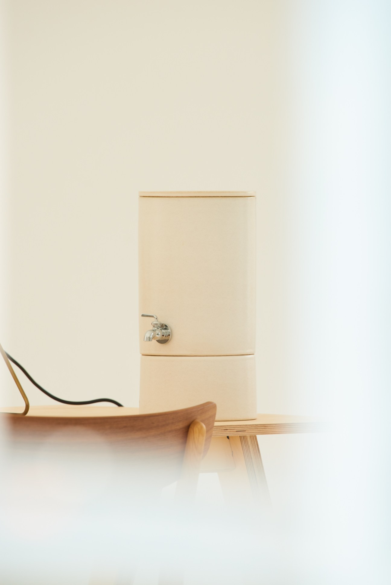 Cleansui water filter with ceramic pot design and metal tap spout on wooden surface.
