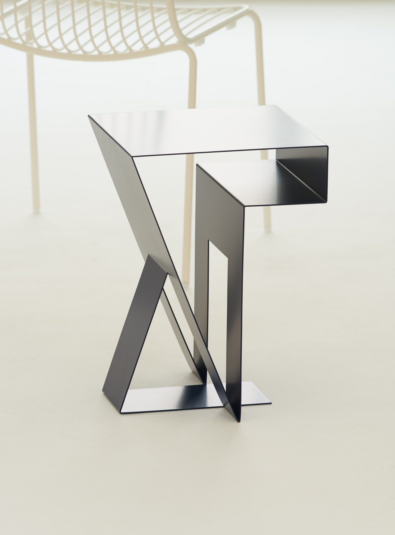 Neumann side table by Objekte Unserer Tage with sculptural laser-cut steel bent frame.
