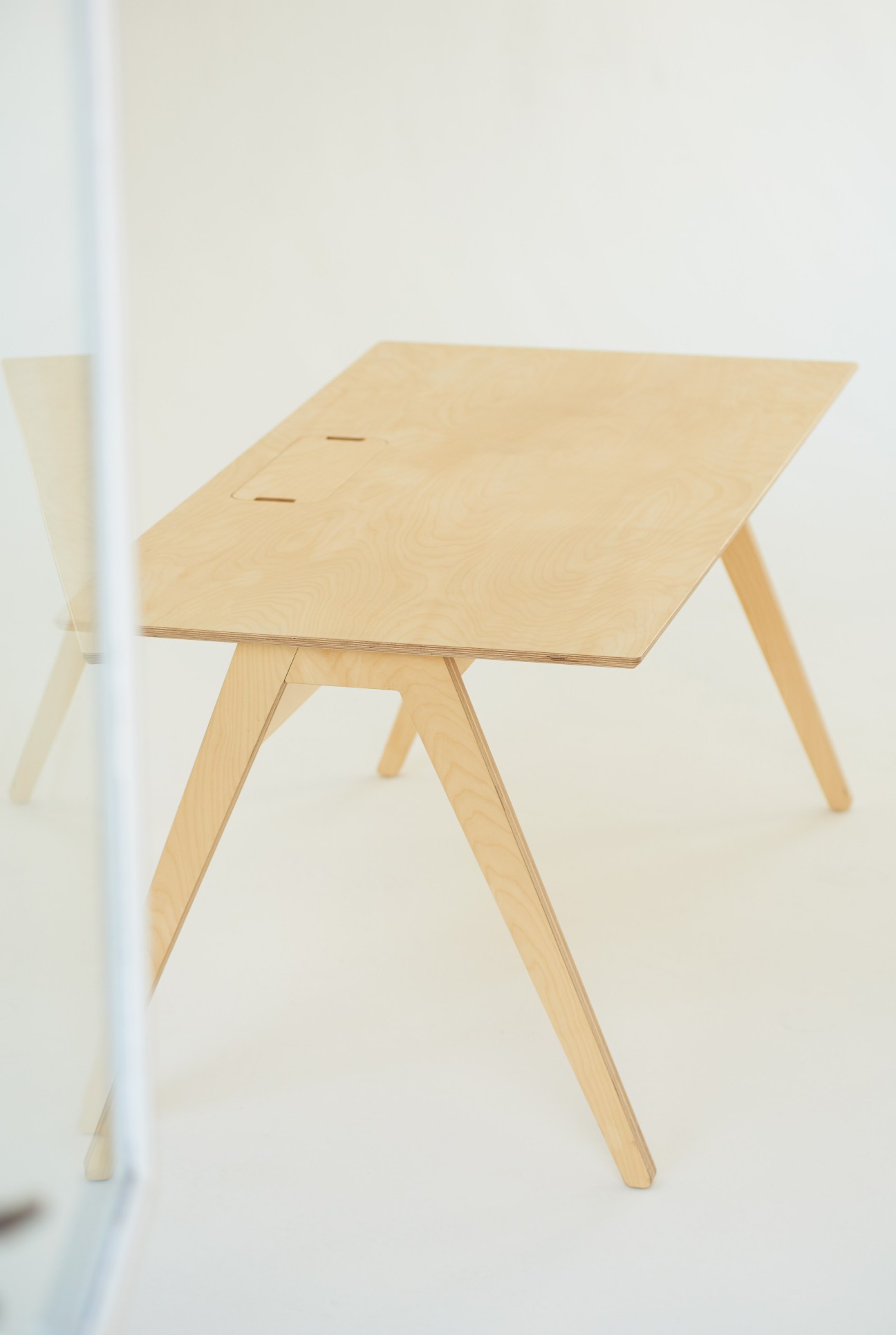 Studio desk by Opendesk with minimalist light wood design and cable management.