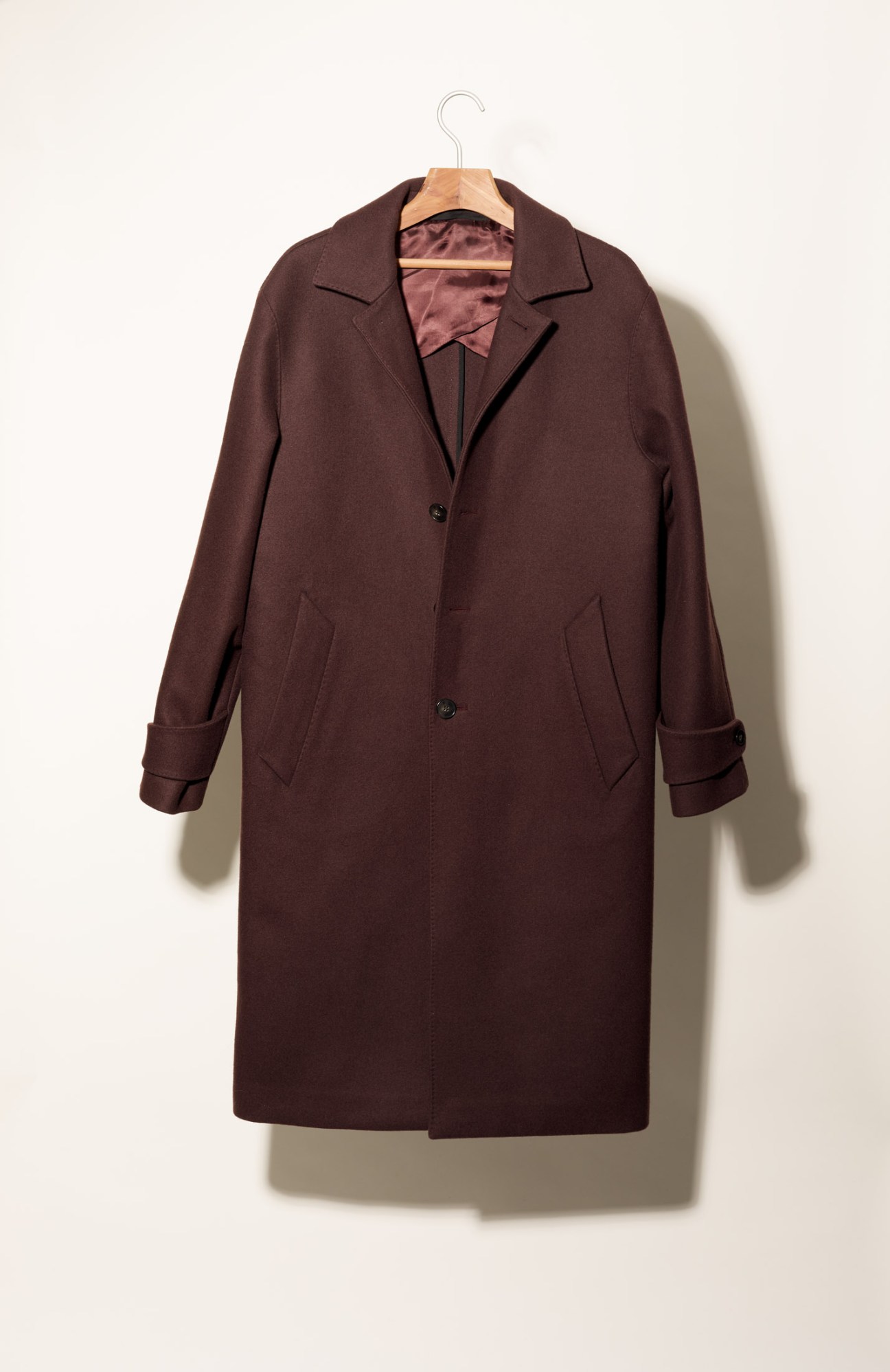 Officine Générale burgundy wool coat on wooden hanger against neutral background