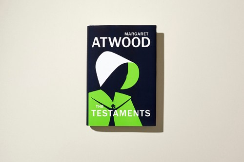 Book cover of Margaret Atwood's "The Testaments" featuring black background with white and lime green design elements.