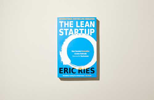 The Lean Startup by Eric Ries book cover with blue and white design on beige background.