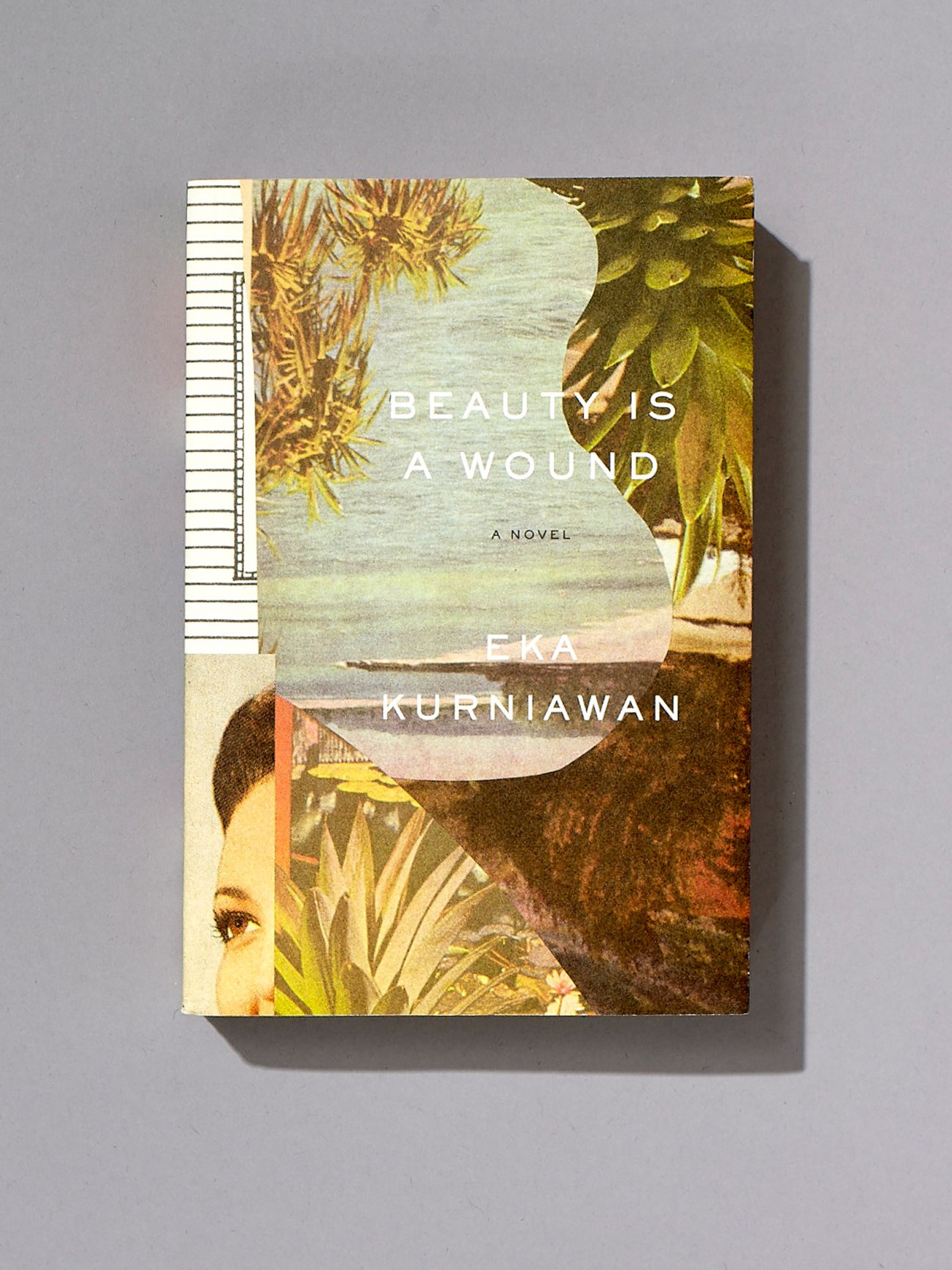 Book cover for 'Beauty Is a Wound' by Eka Kurniawan, designed by John Gall, featuring collaged vintage imagery with botanical elements and a woman's face.
