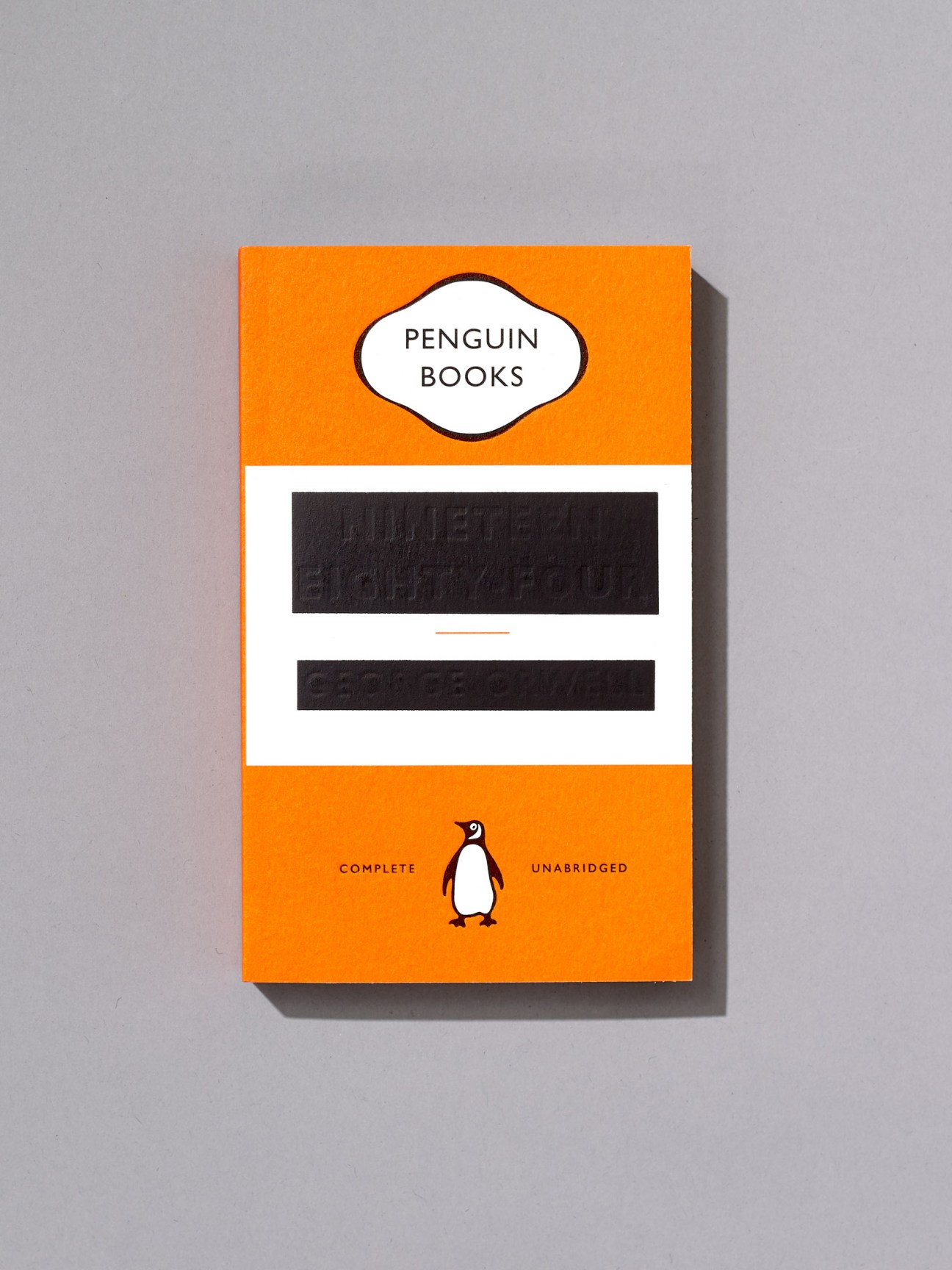 Orange Penguin Books cover with blacked-out title and author text by David Pearson for George Orwell's 1984.