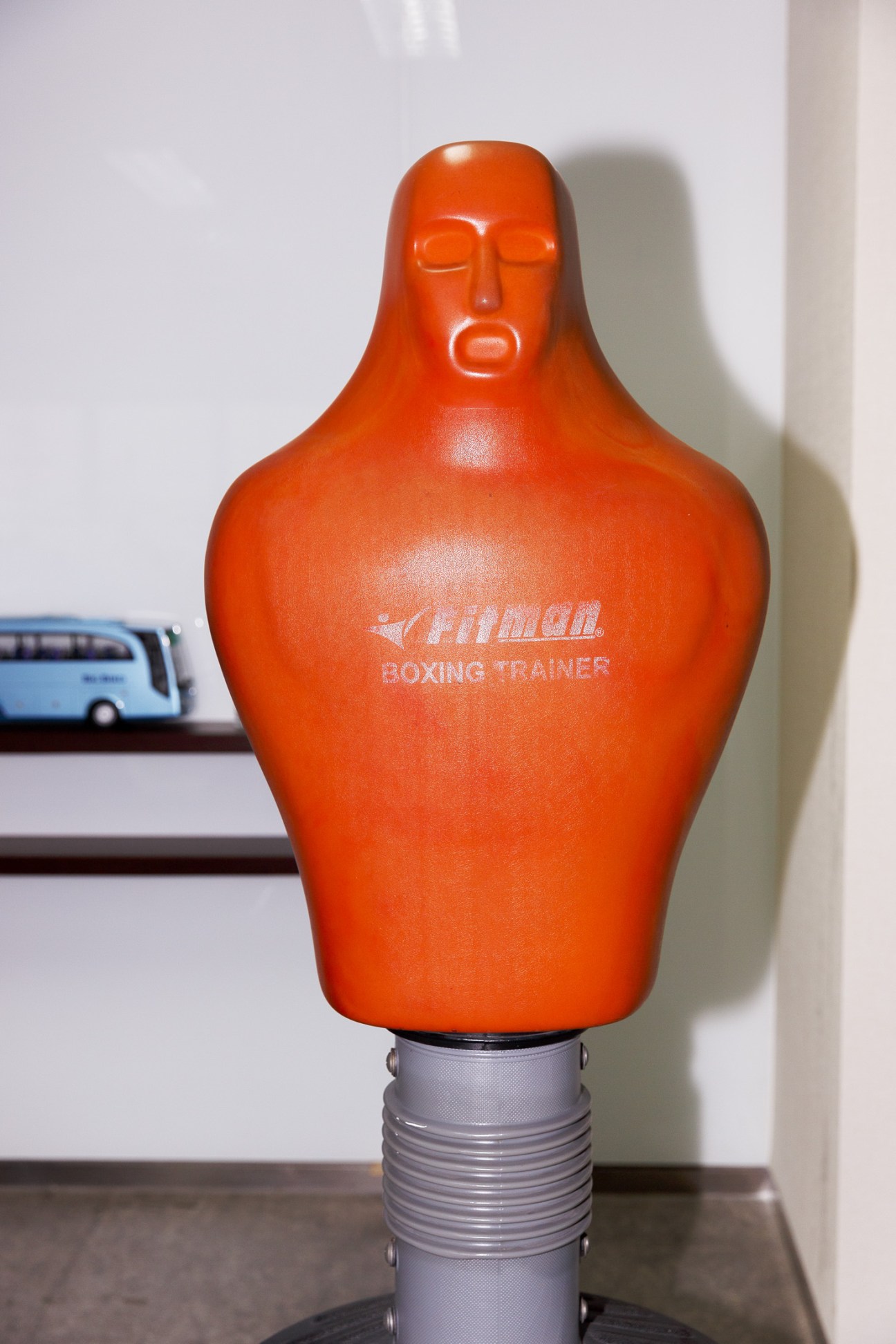 Orange Atiman boxing trainer bag with human-shaped head and torso on gray base.
