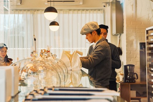 Baker Seok Ho-son arranges pastries in the display case at Aperitif bakery.
