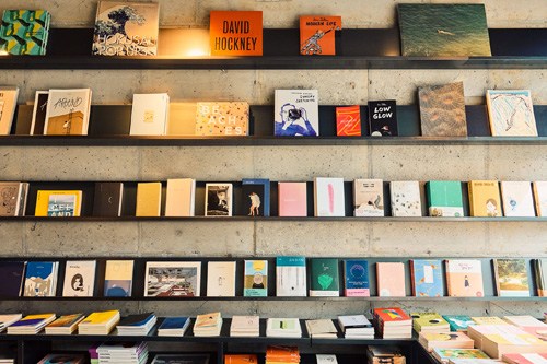 Shelves displaying a curated collection of books and print publications at Strukt café in Gwangju.
