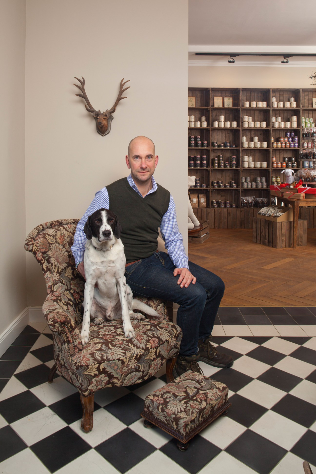 Man with dog sitting in upholstered chair at Sonnenberg pet shop in Berlin