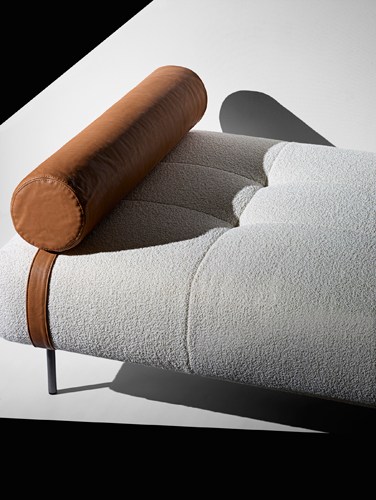 Erei daybed by De Padova with brown leather cylindrical headrest and light grey upholstered seat.