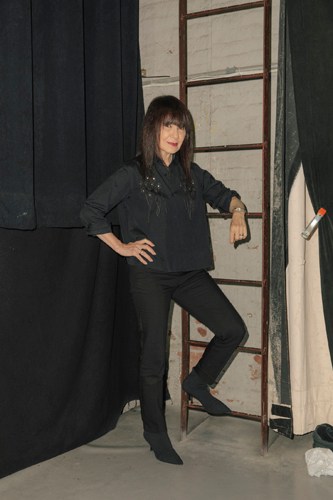 Art historian RoseLee Goldberg poses against a backdrop of black and white panels.