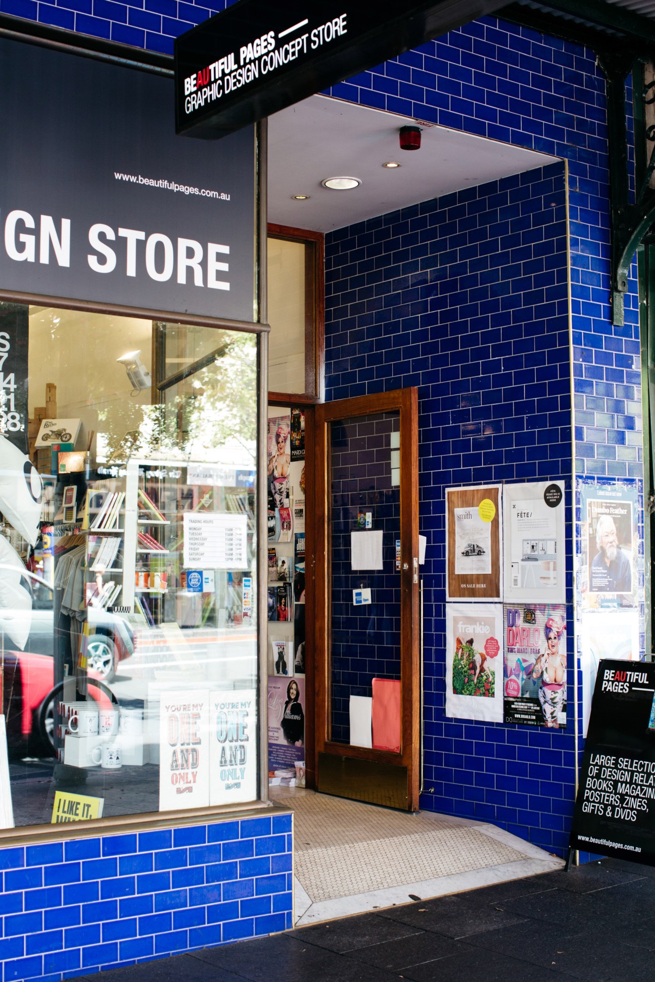 Exterior of Beautiful Pages bookstore with bright blue tiled facade and display window showing design books and magazines