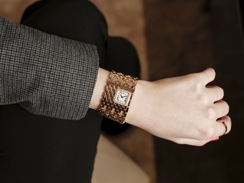 A woman's wrist wearing a Cartier Panthère de Cartier Manchette oversized cuff watch with rose-gold soft-link bracelet.