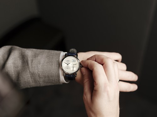 A Lange & Söhne Lange 1 25th Anniversary Edition luxury watch on a wrist with black leather strap.