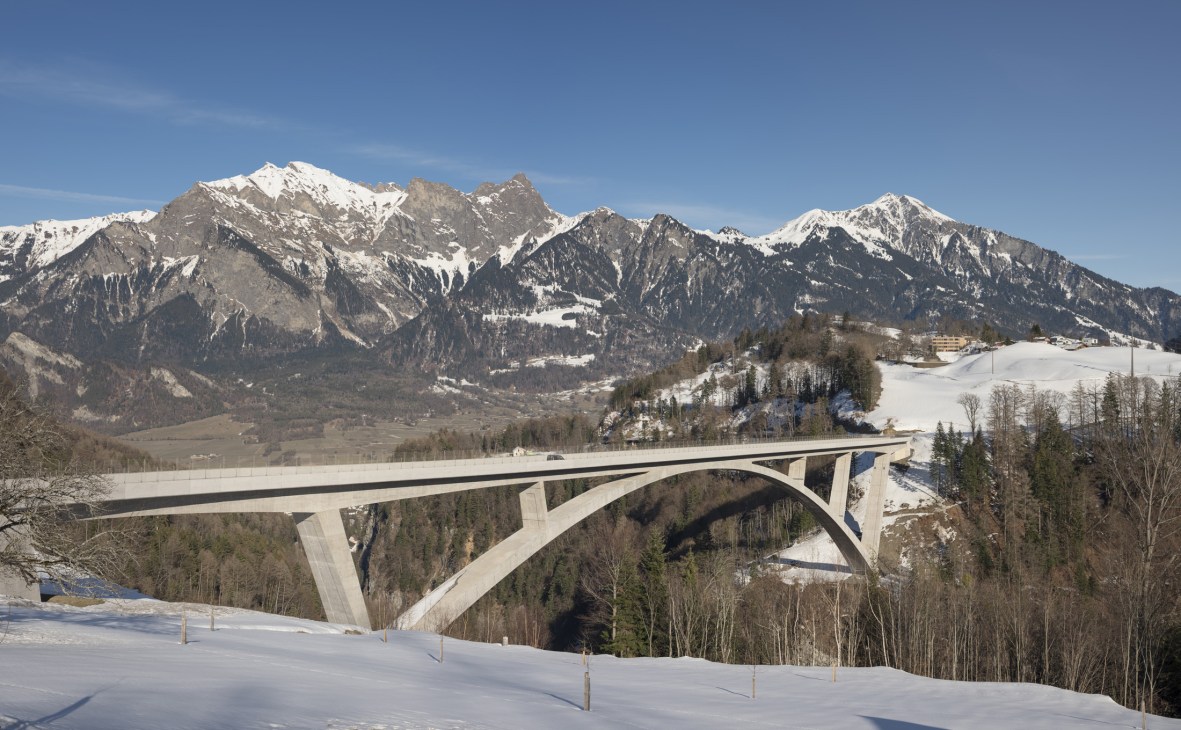 Tamina Bridge spanning a snowy Alpine valley with snow-capped mountains in the background.