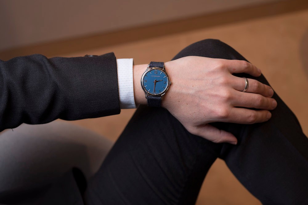 Person wearing a Chopard LUC XP watch with navy dial and merino-wool strap on their wrist.