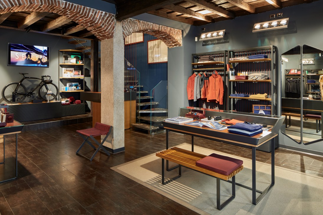 Interior of Sease shop in Milan featuring leather armchairs, outdoor gear, and sailing-themed decor.