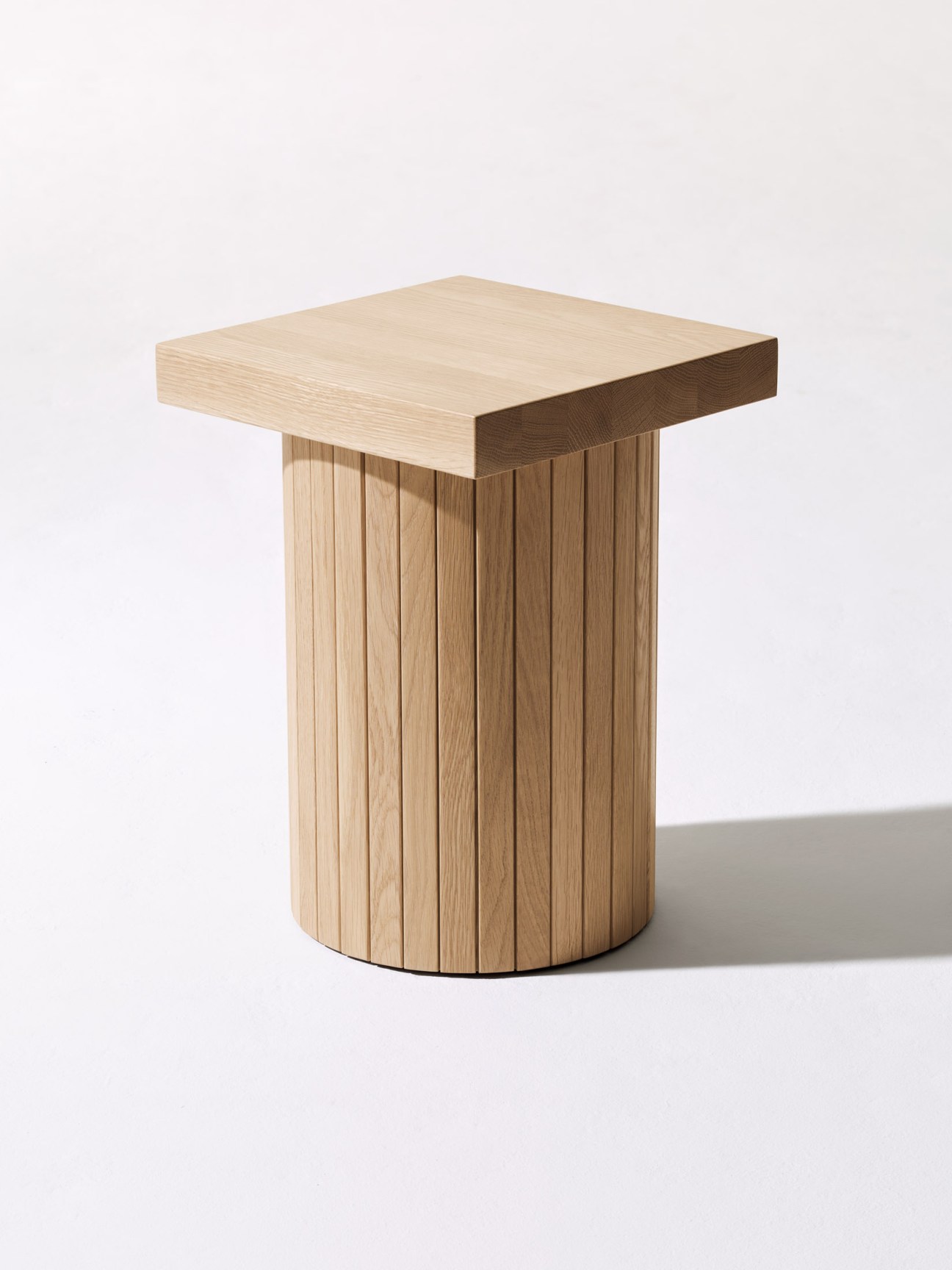 Wooden stool with vertical slat base and square top by designer Kevin Seitz.