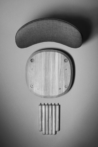 Flatpack chair components displayed vertically: fabric seat, wooden base, and metal legs.
