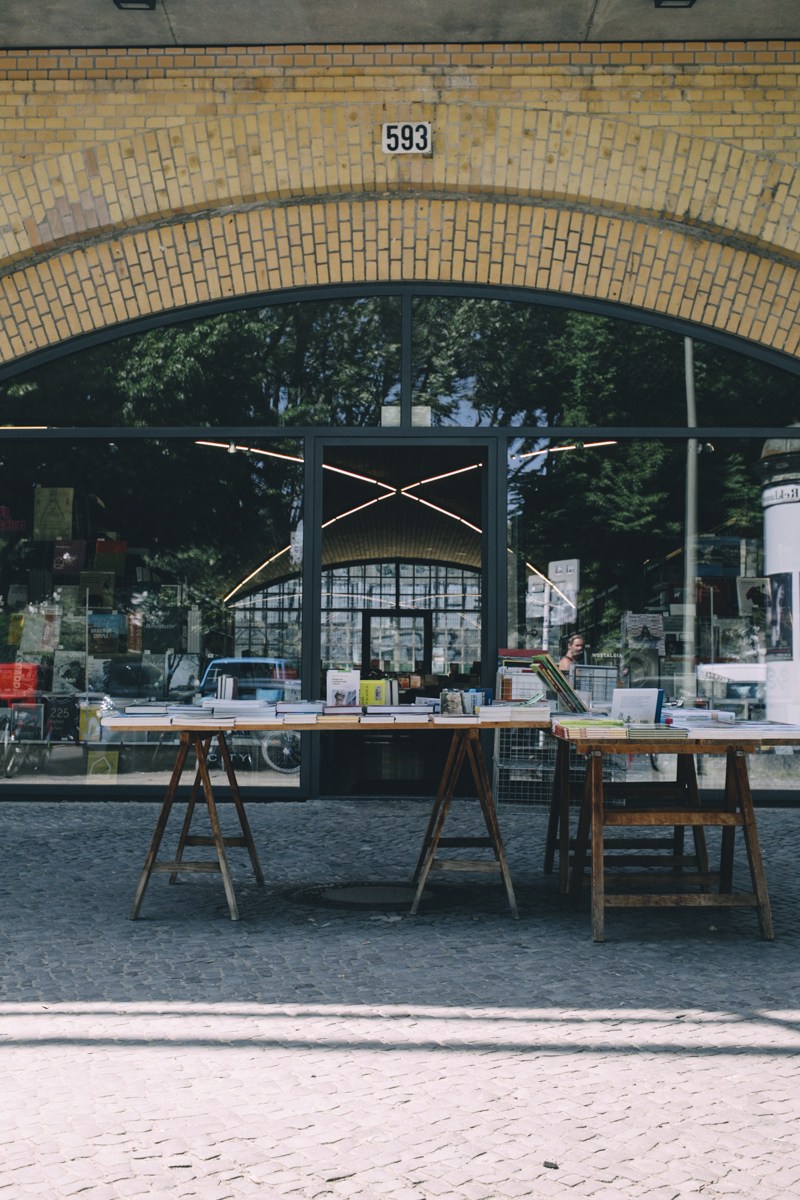 Bücherbogen bookshop storefront under arched brick railway bridge with number 593 displayed.