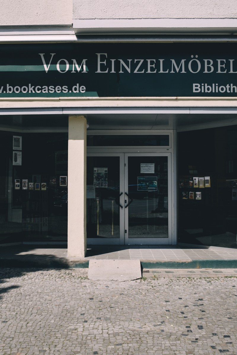 Bookcases furniture showroom storefront in Berlin with dark signage and glass doors.