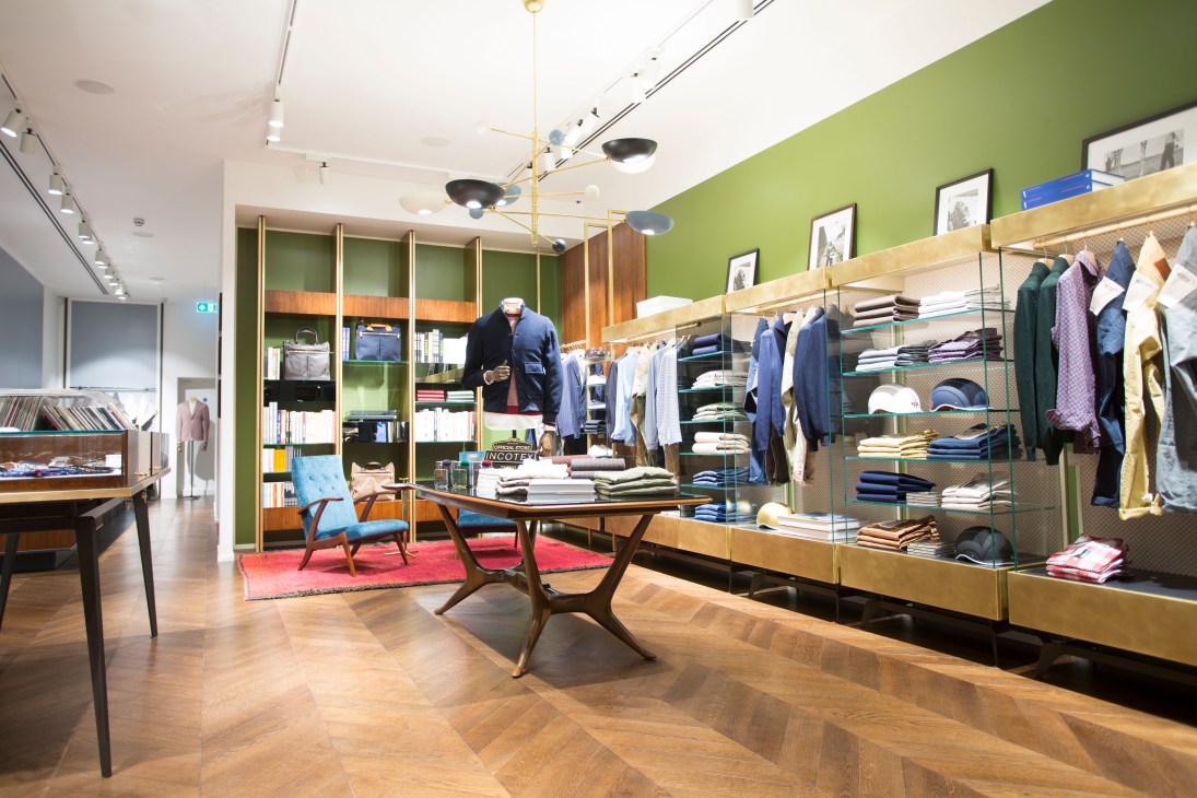 Slowear menswear shop interior on King's Road with green walls, wooden shelving, and clothing displays.