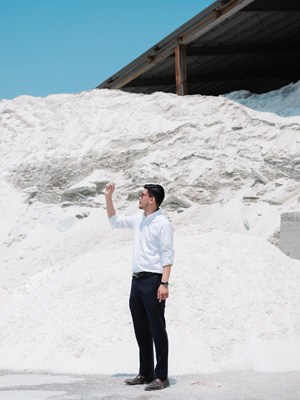 Wu Ting-an stands in front of a large white pile of recycled glass material at Spring Pool Glass in Hsinchu, Taiwan.