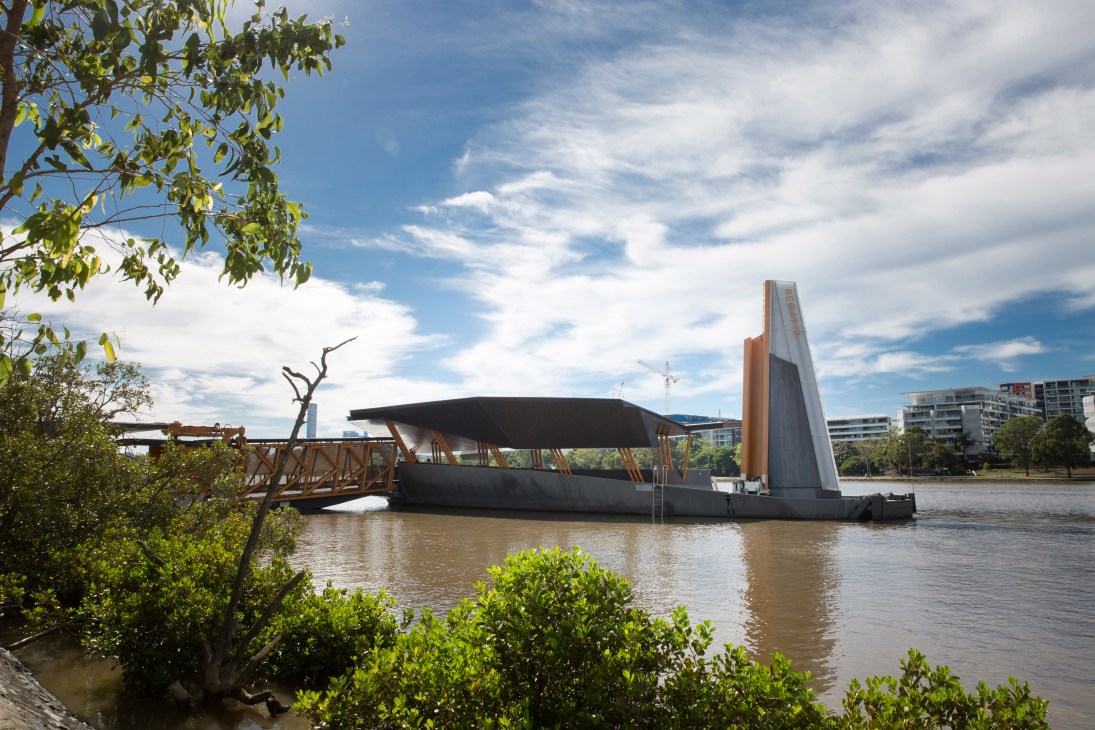 Modern ferry terminal with black hull-shaped structure and wooden gangway on Brisbane river surrounded by mangroves.