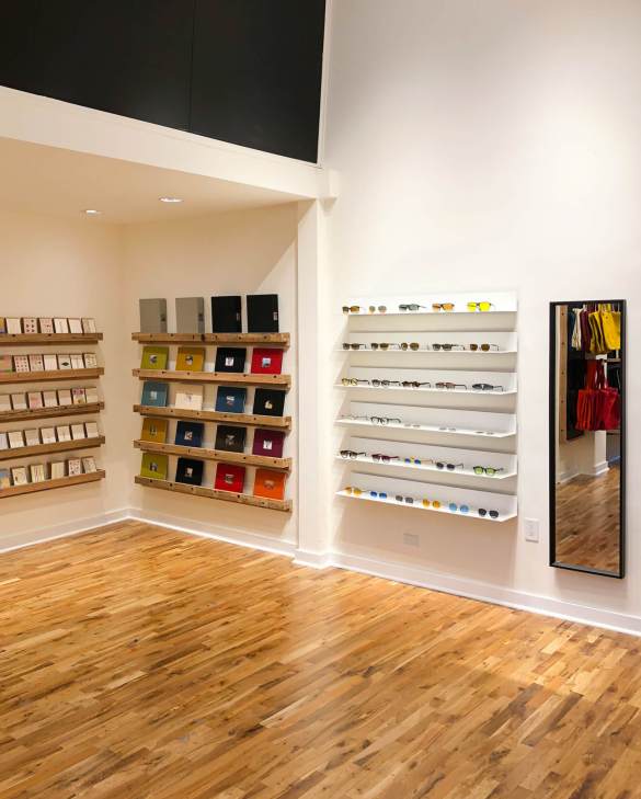 Interior of Kolo Topdrawer San Francisco store showing wooden shelving with stationery, eyewear displays, and clothing racks.