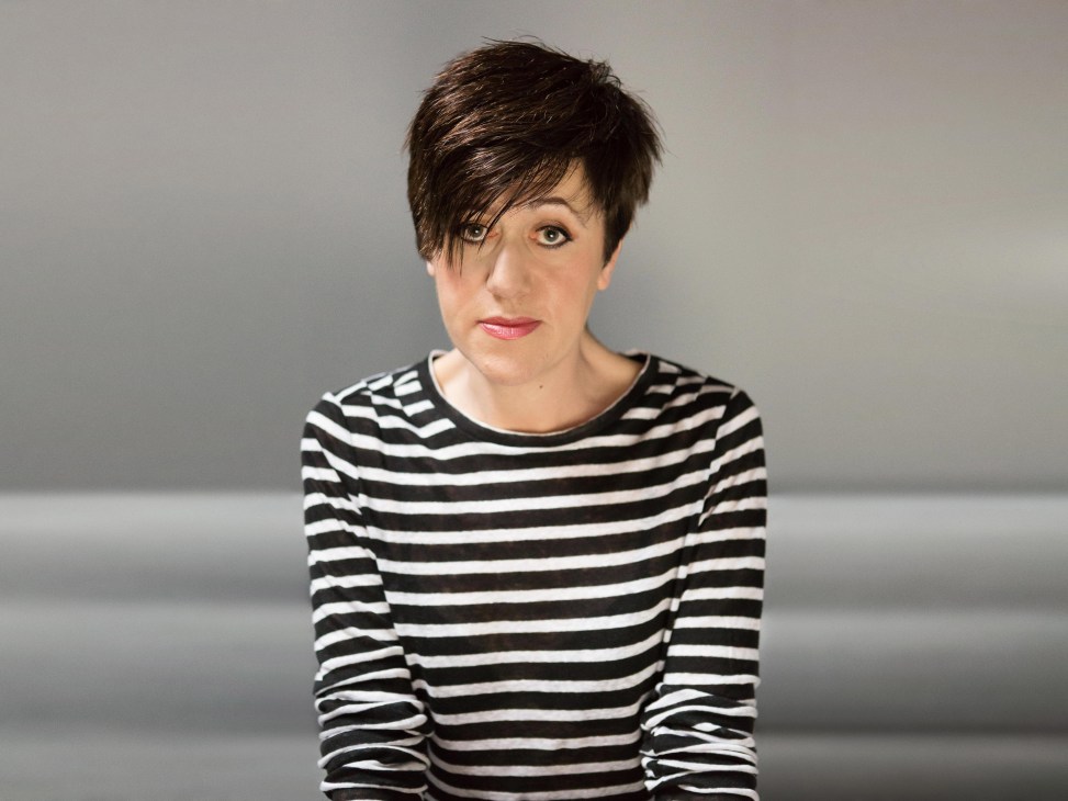 Portrait of Tracey Thorn wearing a black and white striped long-sleeve shirt against a gray background.