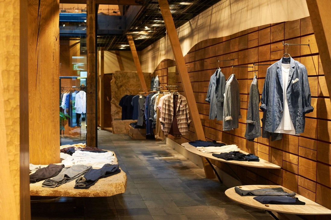 Interior of 45R clothing store displaying indigo-dyed garments and casual wear on wooden wall displays and clothing racks.