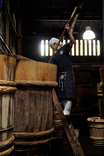 Traditional interior of Sawai Shoyu Honten soy sauce brewery in Kyoto showing wooden fermentation barrels