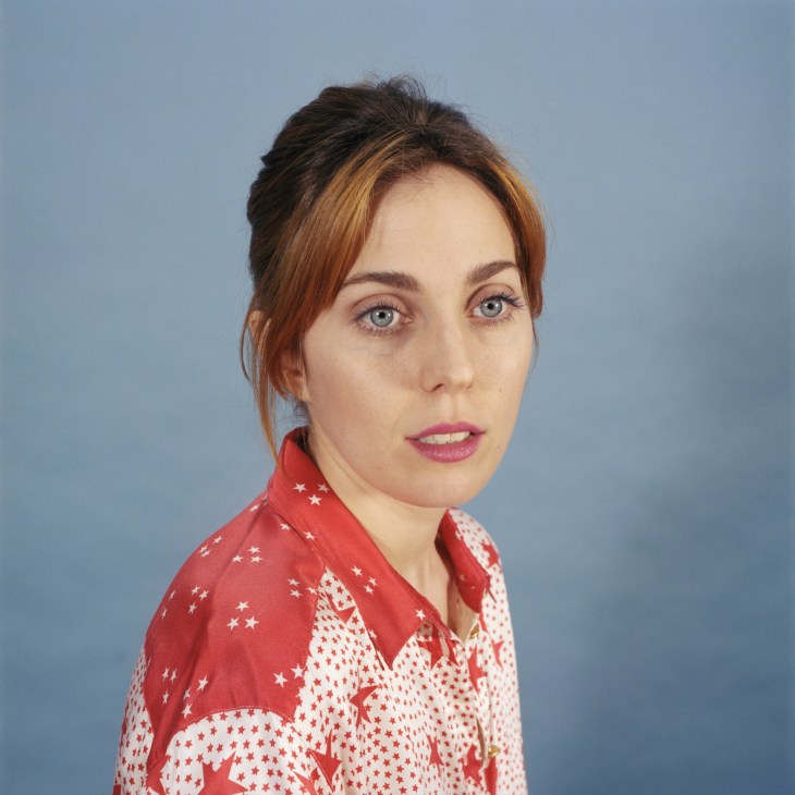 Portrait of Meg Remy from US Girls against blue background wearing red and white star-patterned shirt