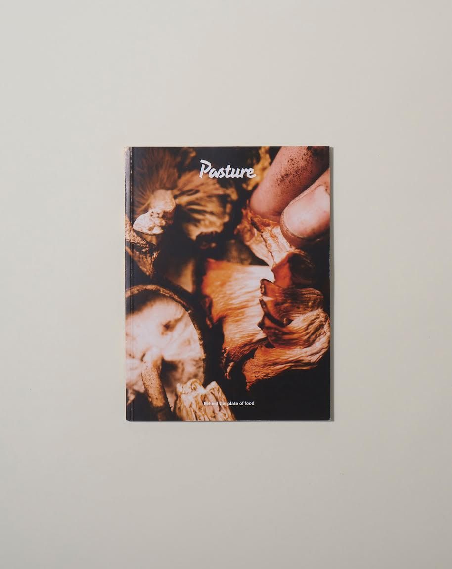 Pasture magazine cover featuring food and hands with warm earth tones and the tagline 'A plate of food'