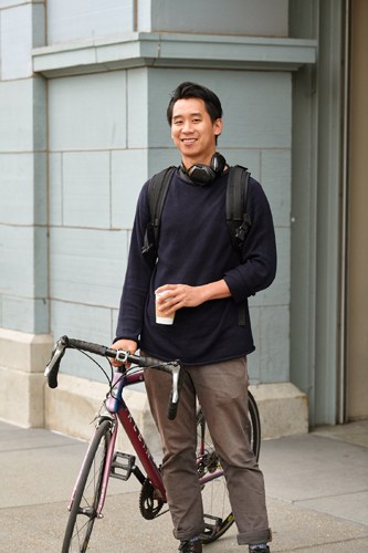 Man holding coffee with bicycle on San Francisco street