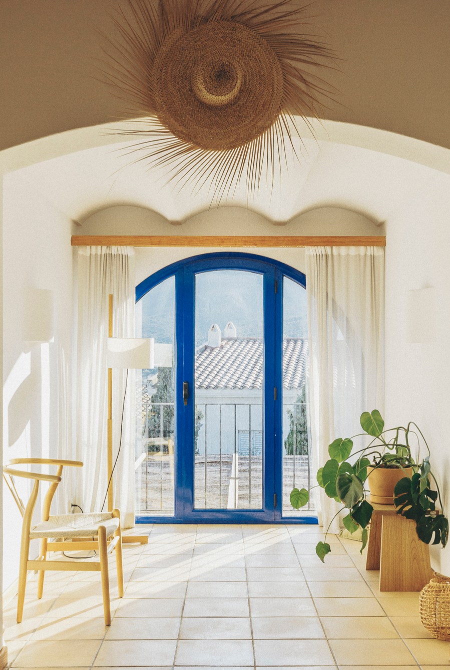 Elegant arched doorway with blue frame and decorative ceiling medallion in Mediterranean-style interior