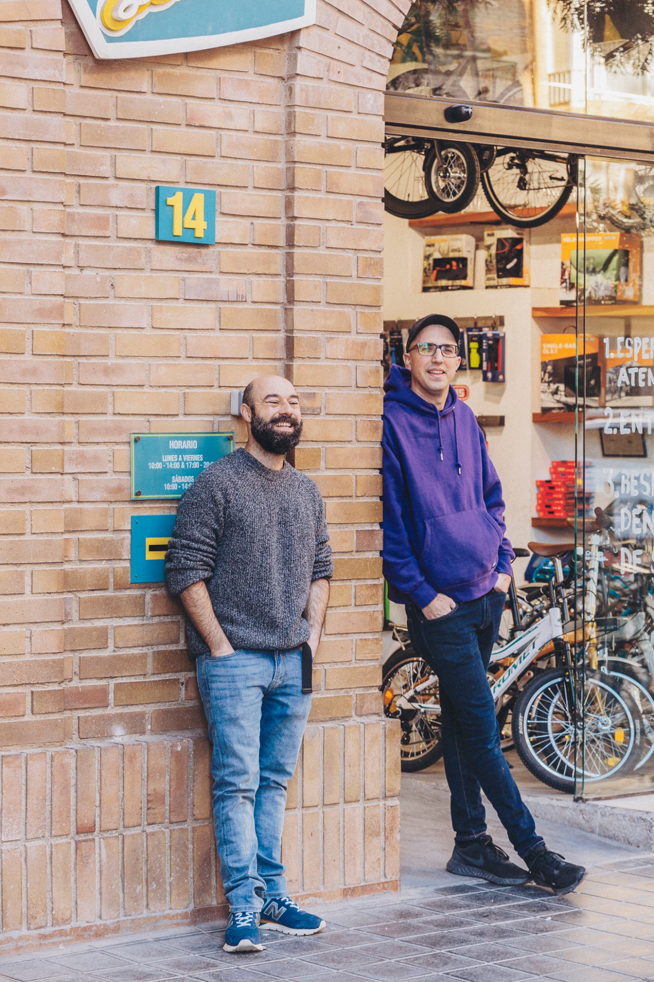 Two bicycle mechanics Manuel Cabezudo and Nacho Durá standing outside their bike workshop