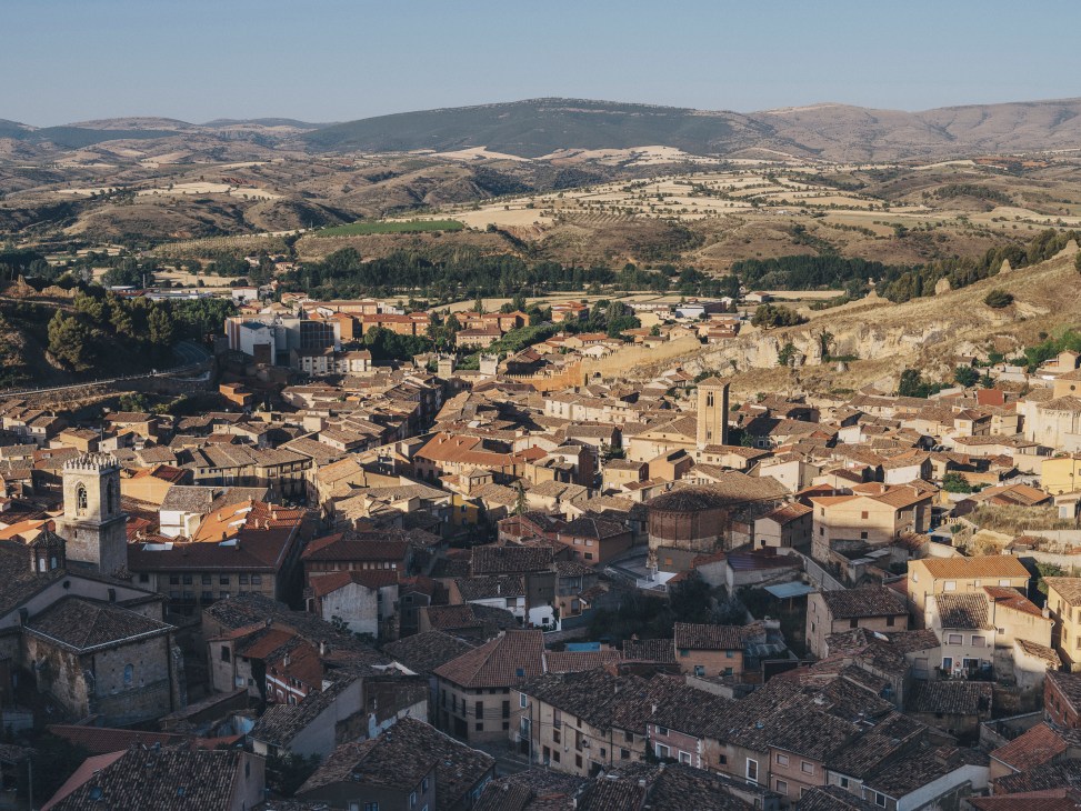 Aerial view of historic town of Daroca with medieval buildings and red tile roofs nestled in rolling hills