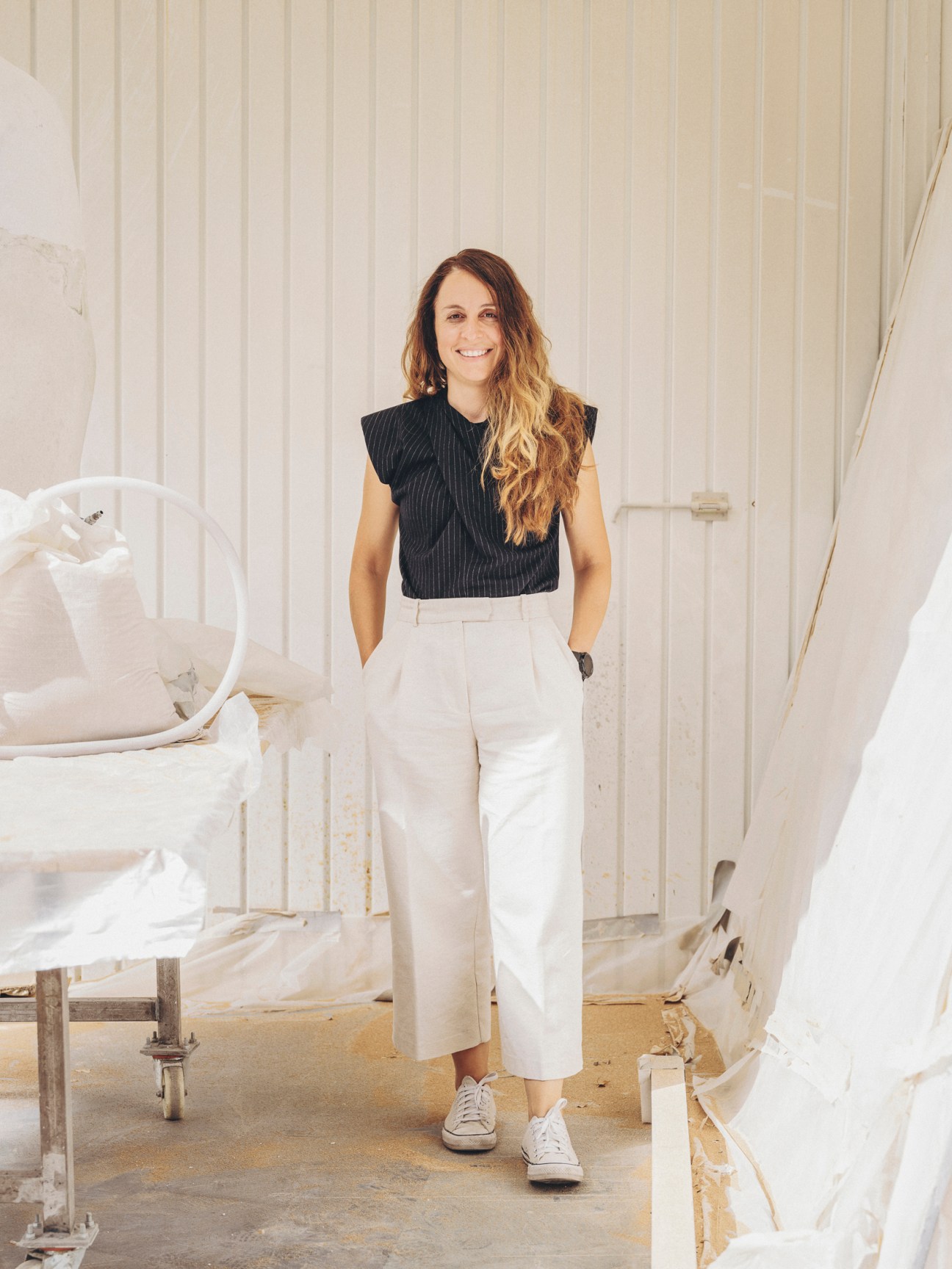 Voula Natsi, a 3D prototyper and scanner at Factum Arte, standing in a workshop with white sculptural forms