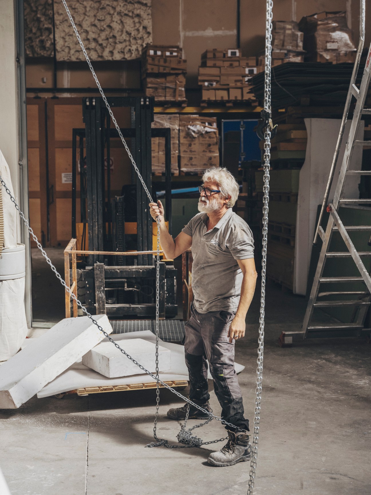Ángel Jorquera, workshop craftsman at Factum Arte, operating chains and pulley system in warehouse