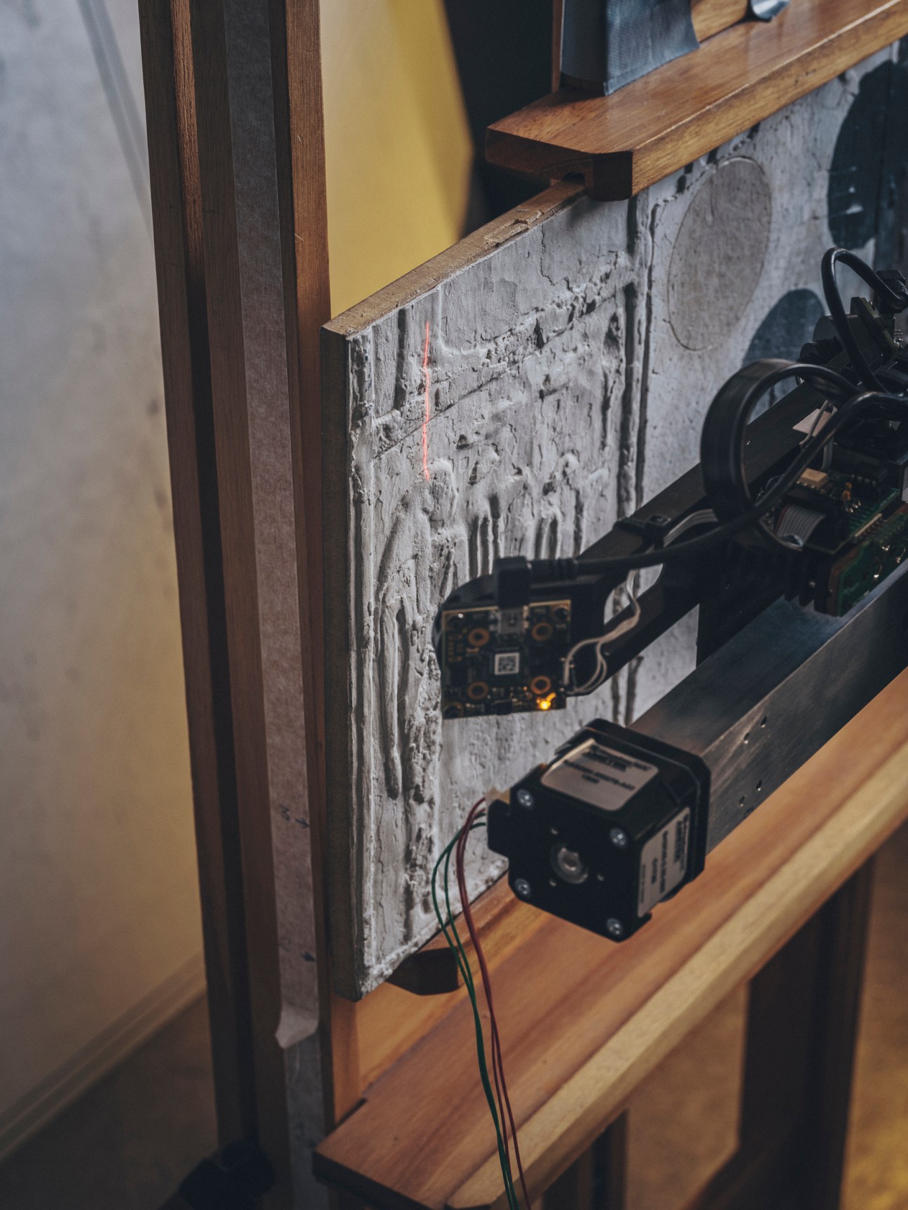 The Lucida 3D scanner positioned over artwork on wooden surface in workshop setting